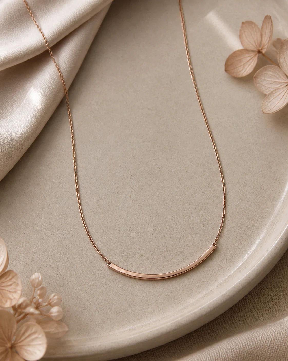 Collar fino de oro rosa sobre fondo greige cálido